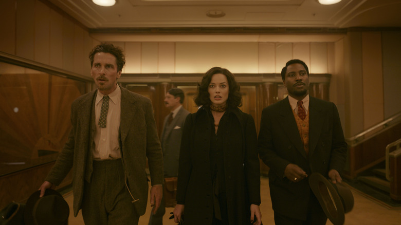 Burt, Valerie, and Harold walk through an ornate hall