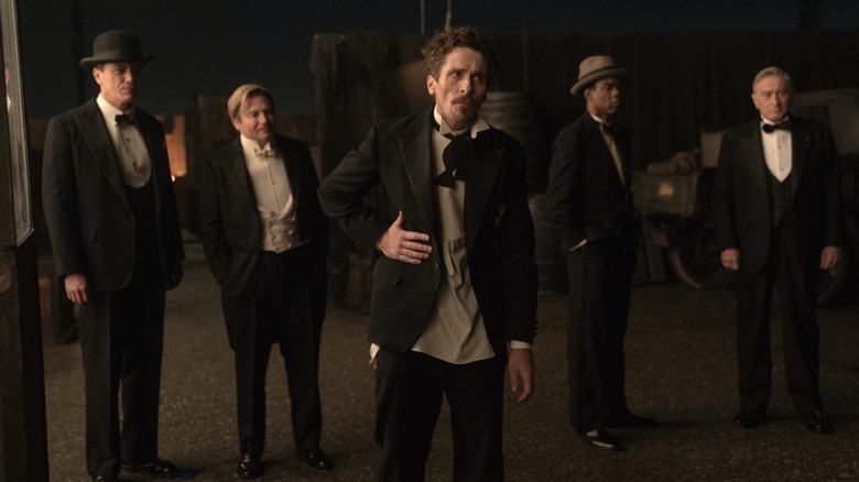 Five men stand in a row wearing formalwear