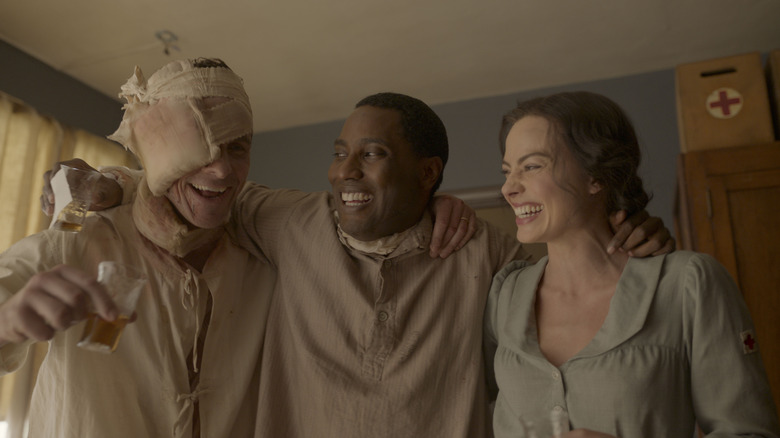 A bandaged Burt stands alongside Harold and Valerie, all smiling