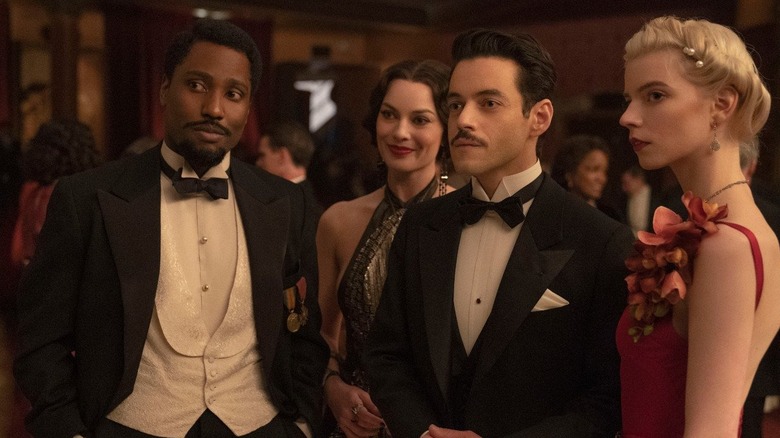 Harold, Valerie, Tom, and Libby stand in the middle of a ballroom in formalwear