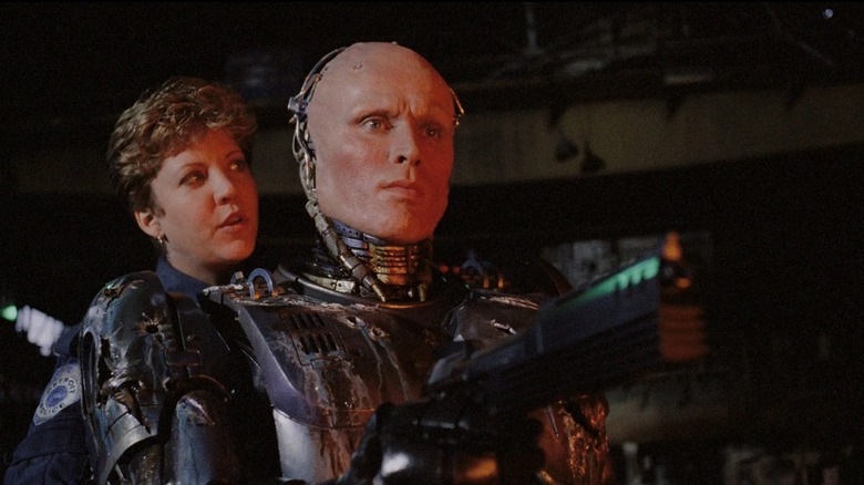 RoboCop aiming a gun with Anne Lewis