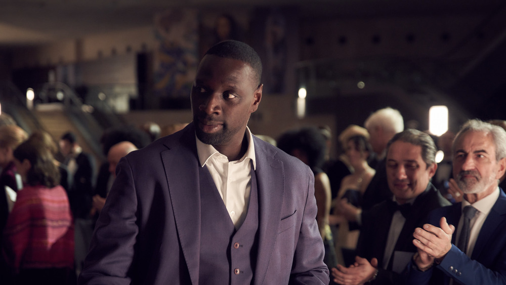 Omar Sy Assane Diop purple suit crowd