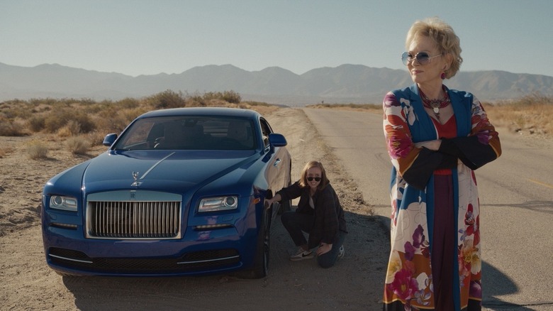 Deborah Vance waits as Ava changes her car's tire