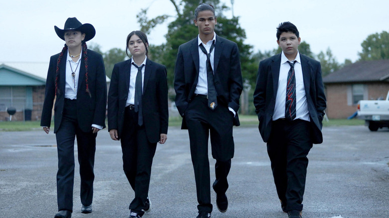 The quartet of Reservation Dogs walk in matching suits