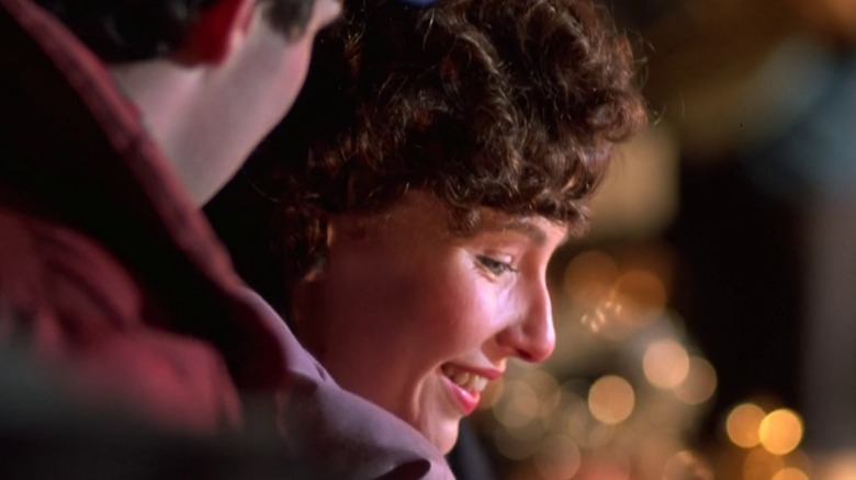 Mary Steenburgen as Ginny Grainger smiling and looking down amid lights in One Magic Christmas (1985)