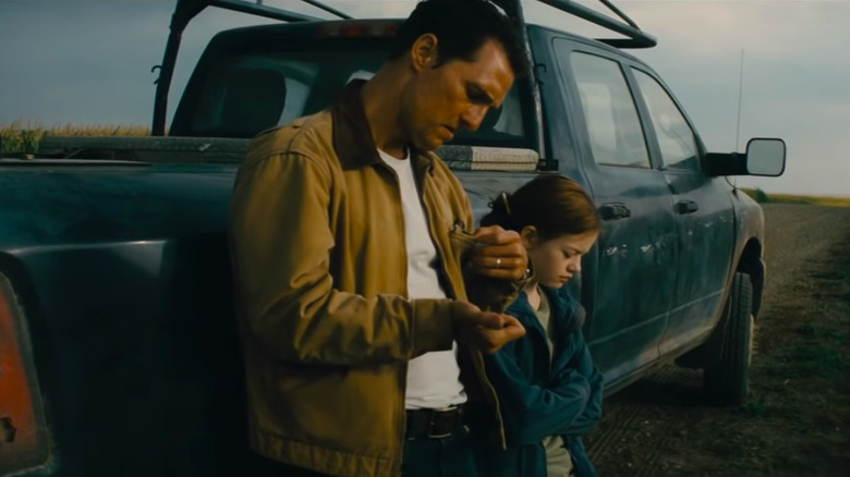 Young Murphy and her father leaning against their pickup truck