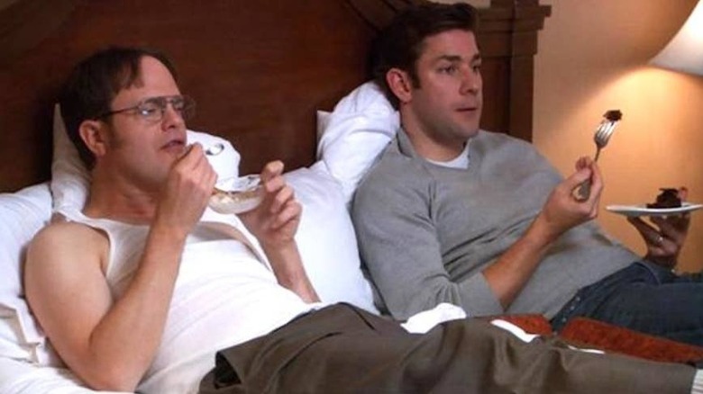 Dwight and Jim eating dessert on bed