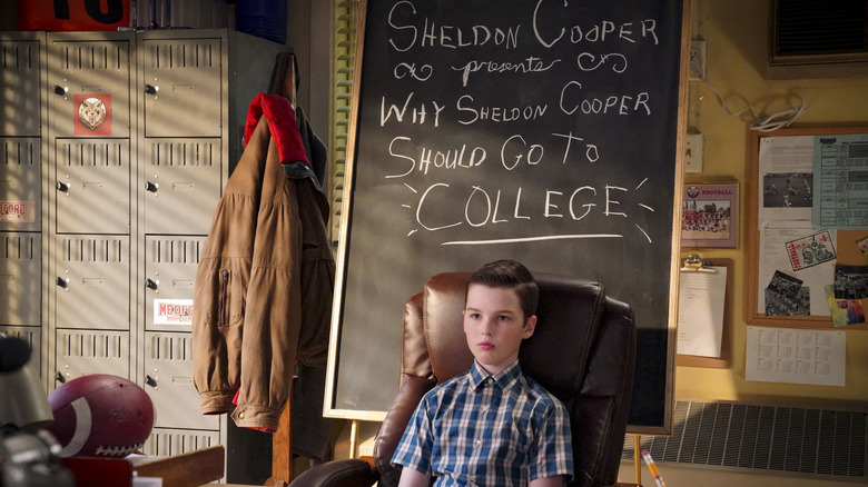 Sheldon sitting in front of chalk board