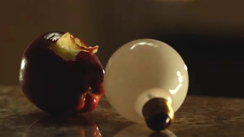 An apple and lightbulb on table
