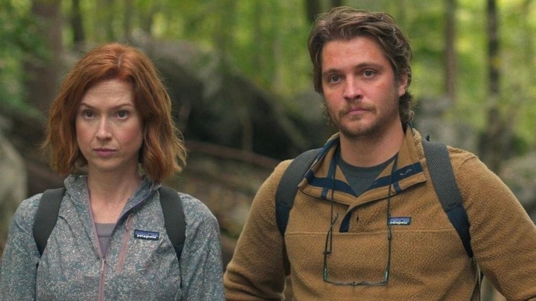 Helen and Jake standing side-by-side in the woods