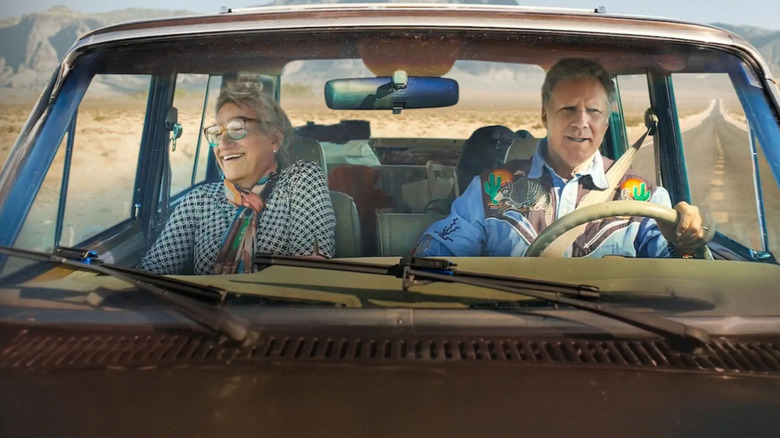 Harper Steele and Will Ferrell drive in a car with the desert laid out behind them