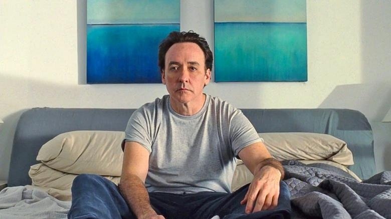 John Cusack sitting in bed