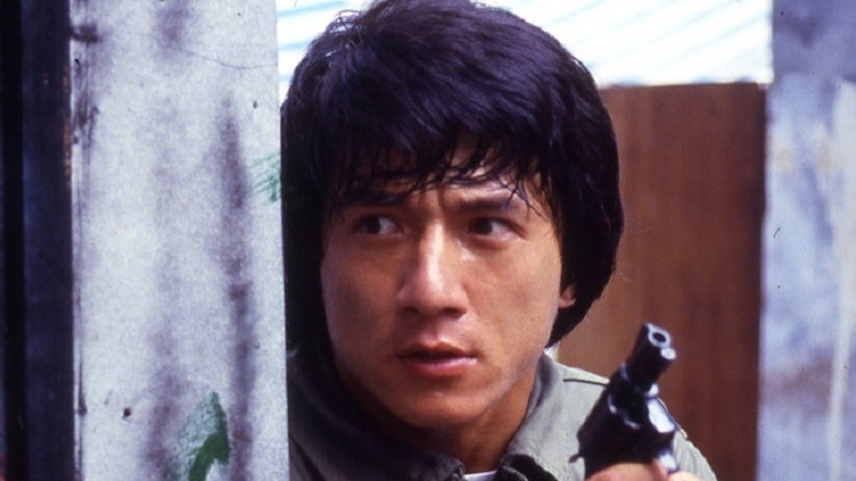 Jackie Chan hiding behind wall