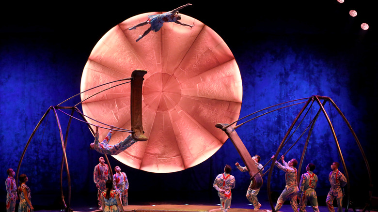 Cirque du Soleil acrobats perform flying leaps through the air