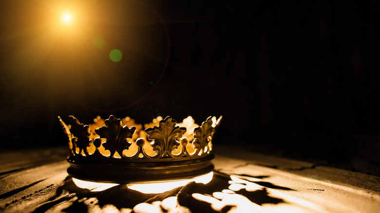 A medieval crown rests in a spotlight