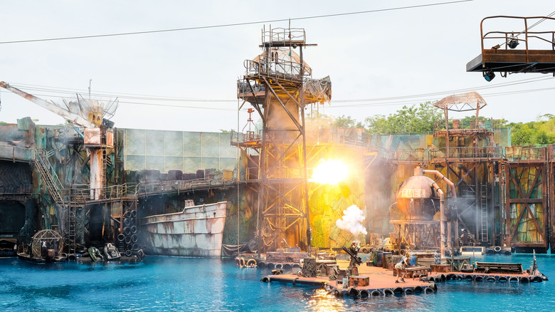 Explosions detonate on a set recreating a dock scene from Waterworld