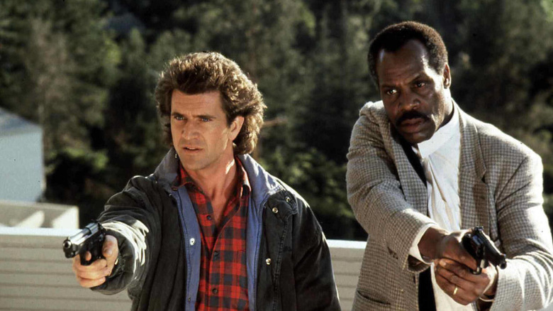 Mel Gibson and Danny Glover holding guns