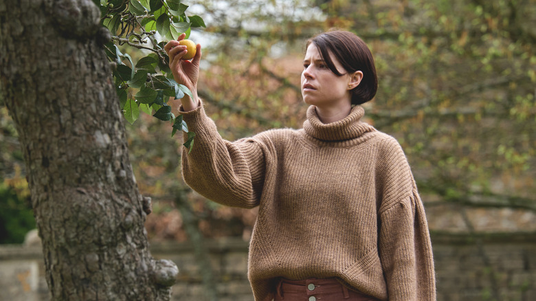 Harper Marlowe picks fruit off tree