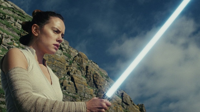 Rey holding lightsaber