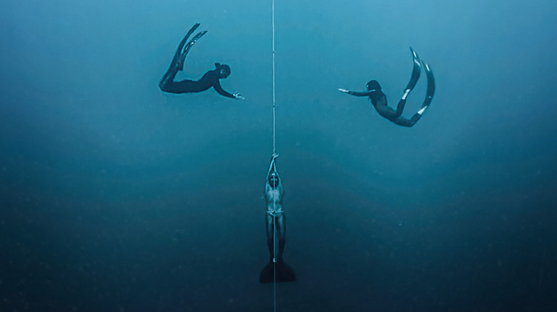 Three divers along a rope