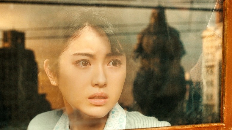 Godzilla: Minus One's Noriko looking at Godzilla through window