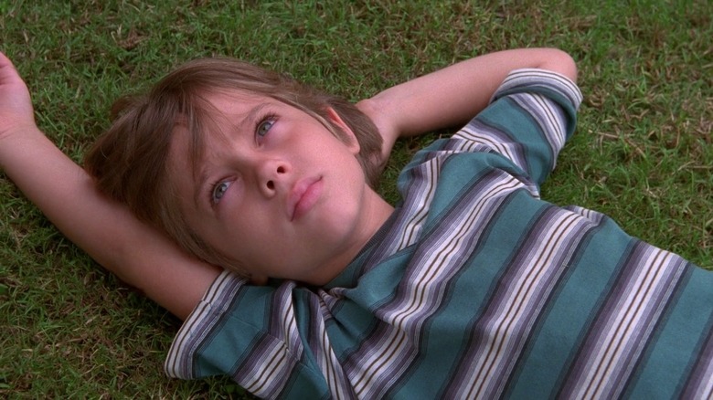 Young Mason sits in grass