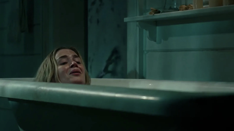 Evelyn gives birth in the bathtub as an alien monster crawls up the stairs in A Quiet Place (2018)