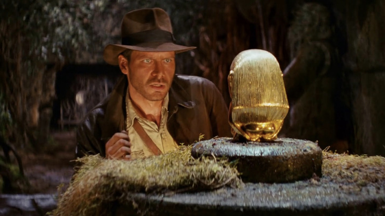 Indiana Jones attempts to remove the idol from the tomb in Raiders of the Lost Ark (1981)