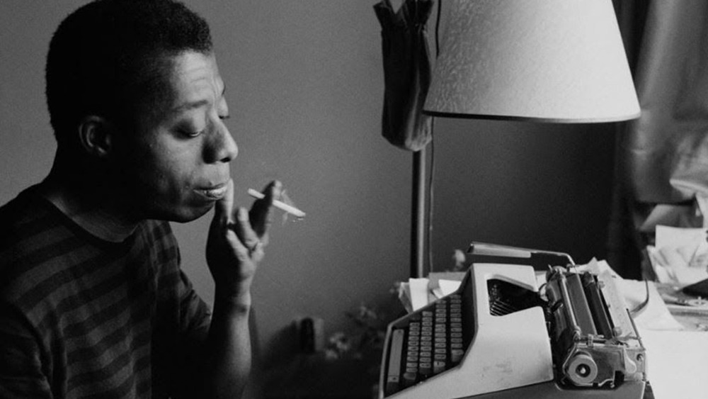 James Baldwin smoking and typing