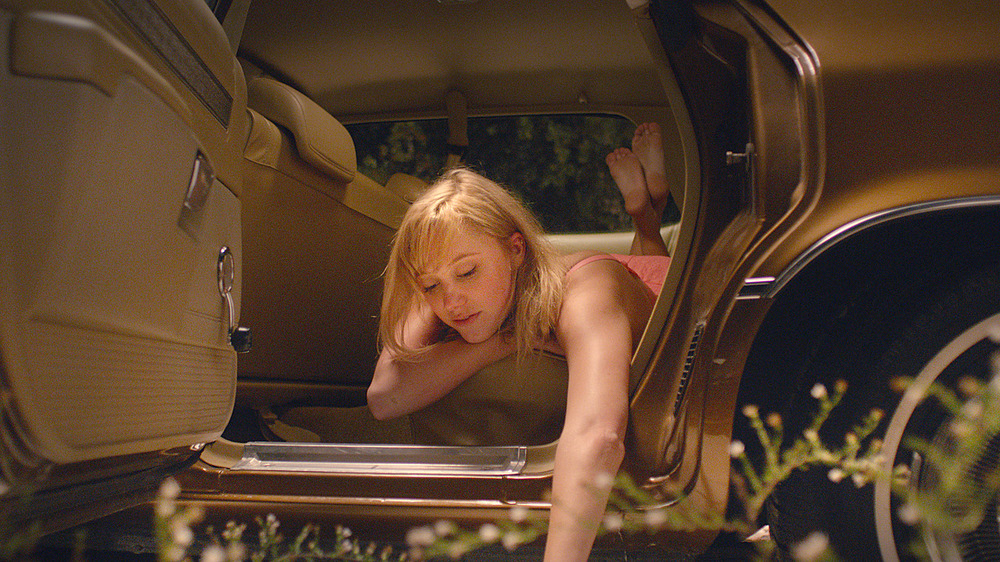 Maika Monroe as Jay lying in car door open