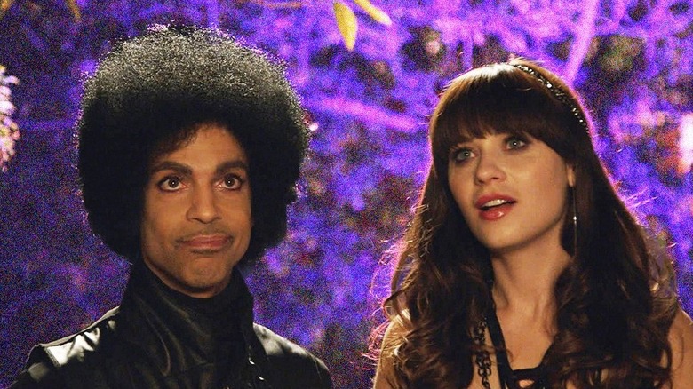 Prince and Zooey Deschanel sit on a bench