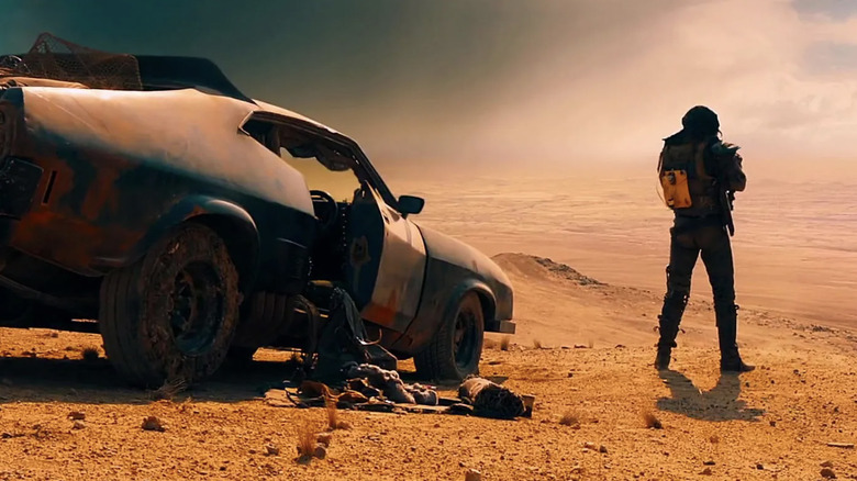 Tom Hardy next to car looking out over desert