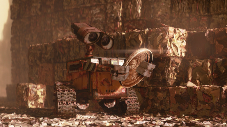 WALL-E holds a disc by piles of trash