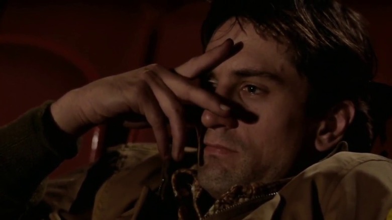 Travis Bickle watching a movie between fingers