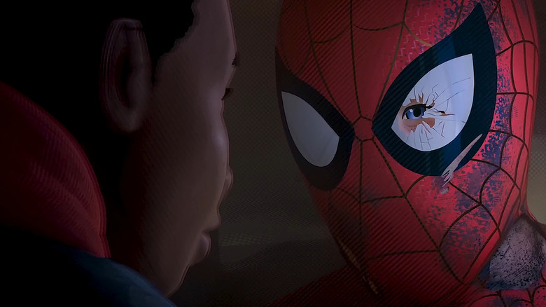 Spider-Man wearing a broken mask, talking to Miles Morales