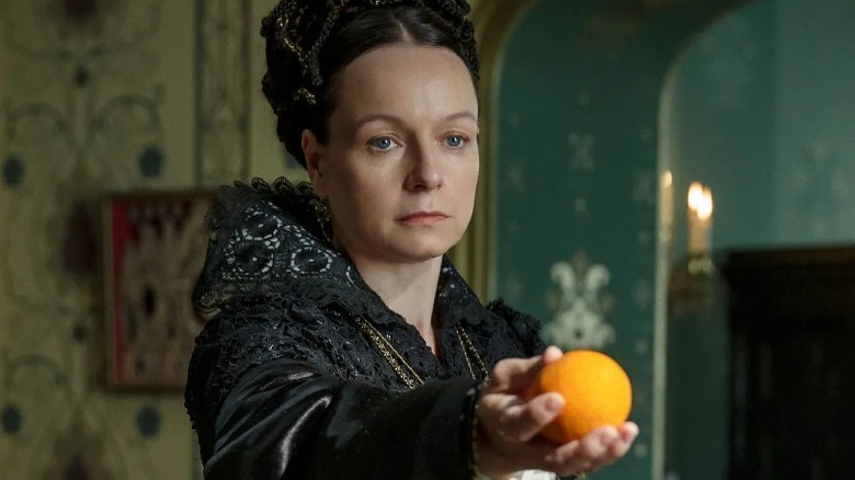 Queen holding an orange