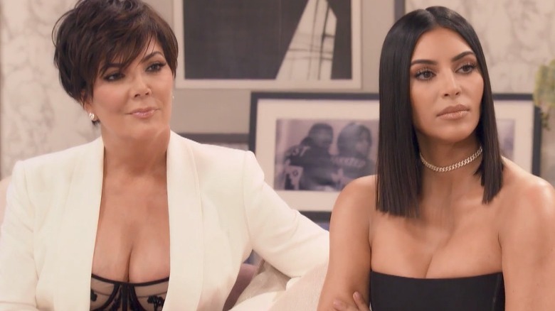 Kris Jenner sitting on a couch with her daughter.