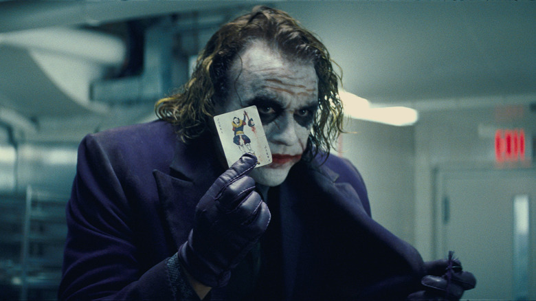 Heath Ledger holding up a card