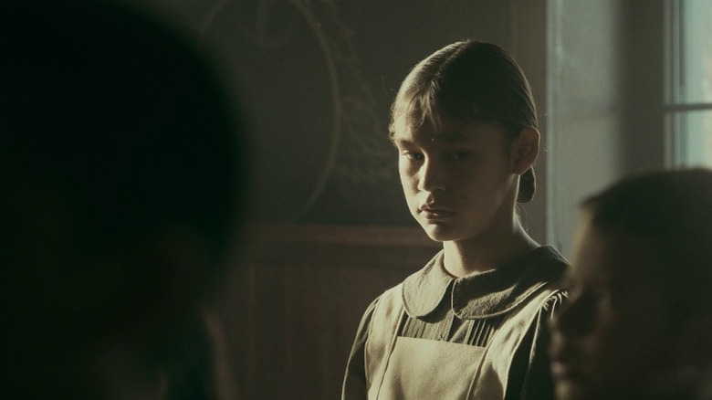 Young Deer Lady standing in a classroom