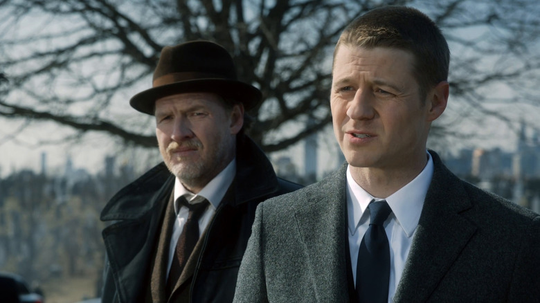 Jim Gordon and Bullock in front of a city skyline