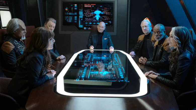 The crew of the Enterprise sits around a table