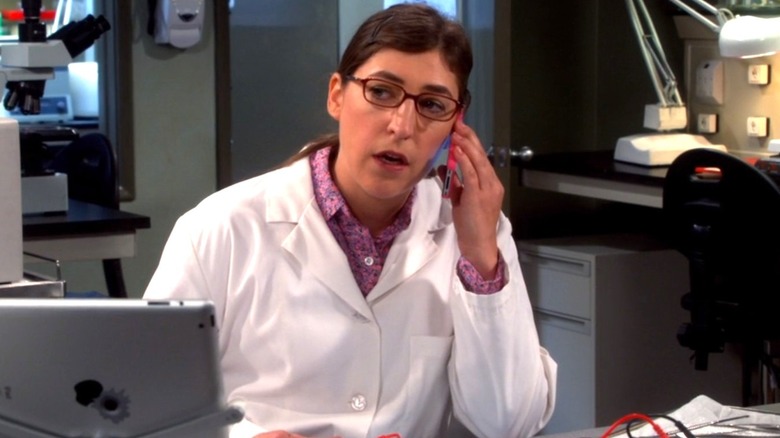 Amy Farrah Fowler sitting on phone lab coat