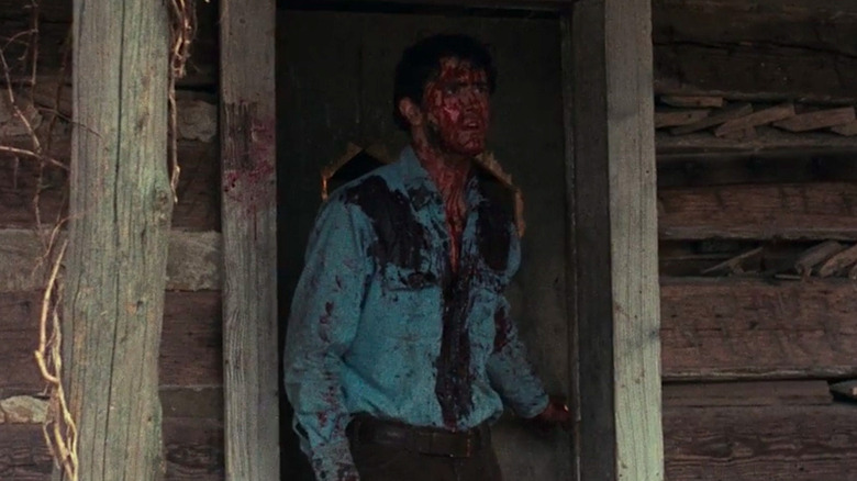 Ash standing on the porch of the cabin in The Evil Dead