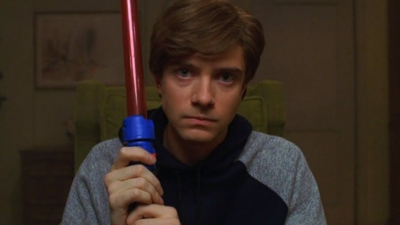 Eric Forman holding a lightsaber