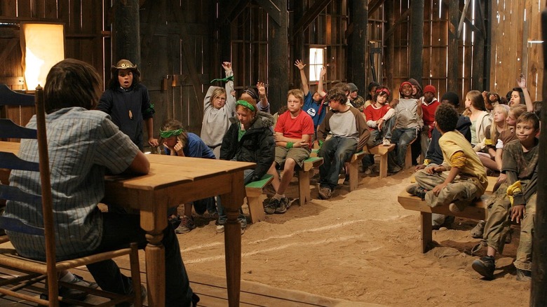 Kids sitting in a barn in Kid Nation (2007)