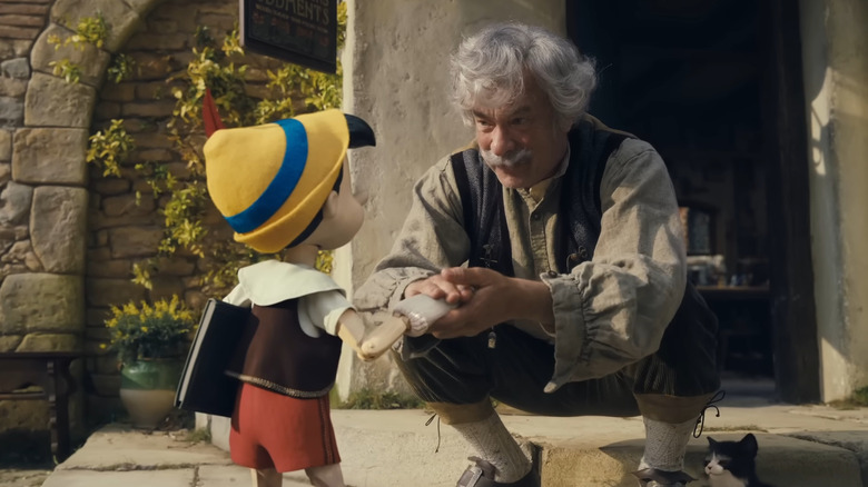 Geppetto grasping Pinocchio's hand longingly as he leaves for school