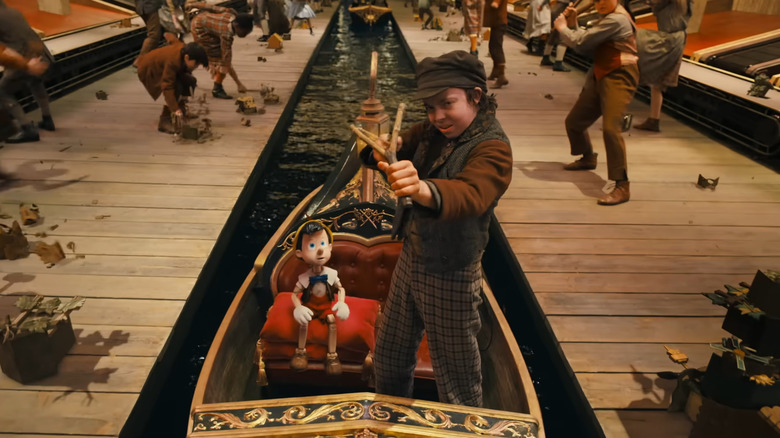 Lampwick shooting a slingshot while Pinocchio looks on