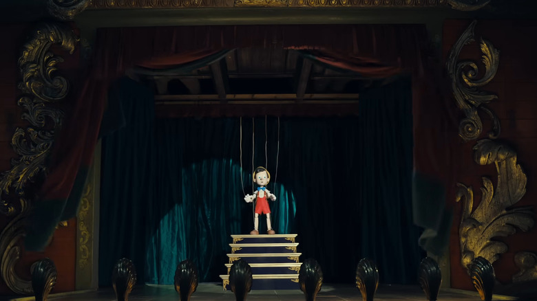 Pinocchio looking startled in the spotlight on stage