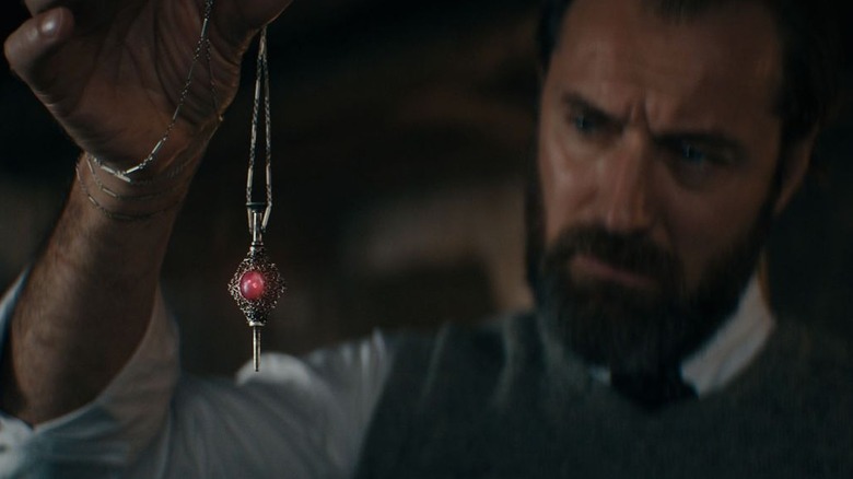 Jude Law looks at locket