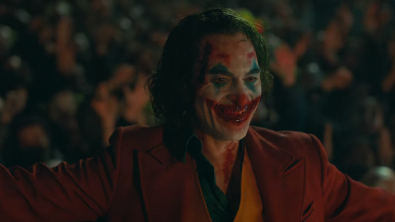 Bloodied Joker smiling in victory